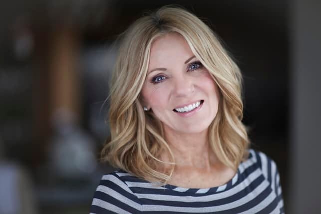 a mature blonde woman is smiling