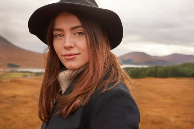 a portrait of a young red-haired girl wearing a hat