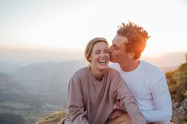 a man kissing his girlfriend’s cheek