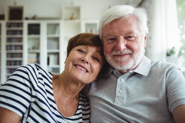 a senior couple is posing together at home
