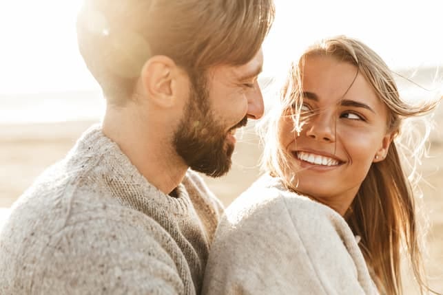 a young couple in love is looking into each others eyes