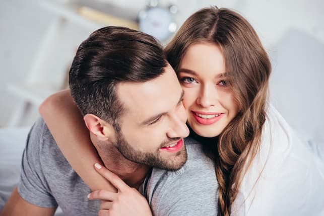 a beautiful couple hugging each other and posing together