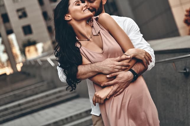 a romantic couple hugging and posing together