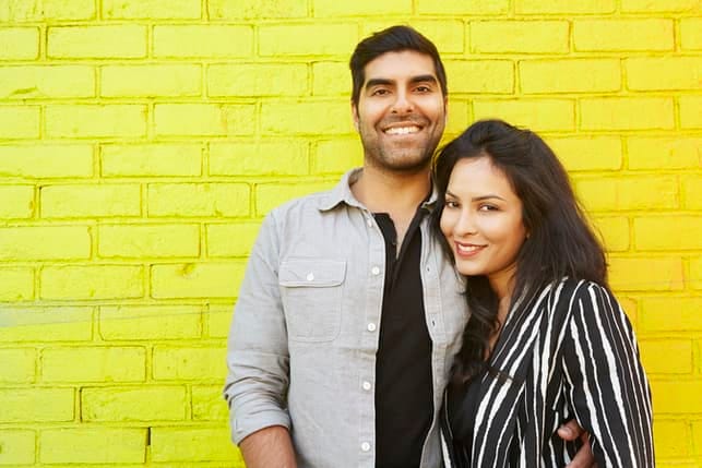 an adult couple posing together and smiling