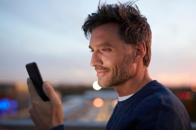 an attractive man checking his phone’s messages