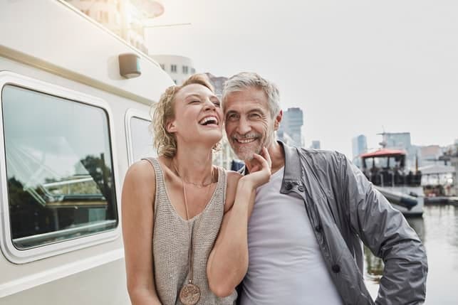 a happy mature couple smiling and laughing together outdoors