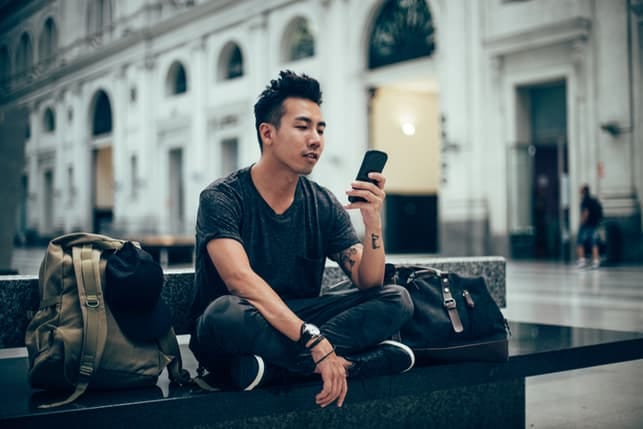 a young man checking his phone outdoors