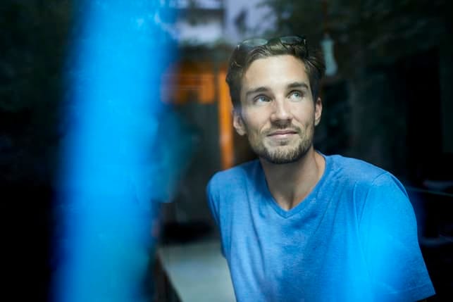 a man wearing a blue shirt thinking about his future